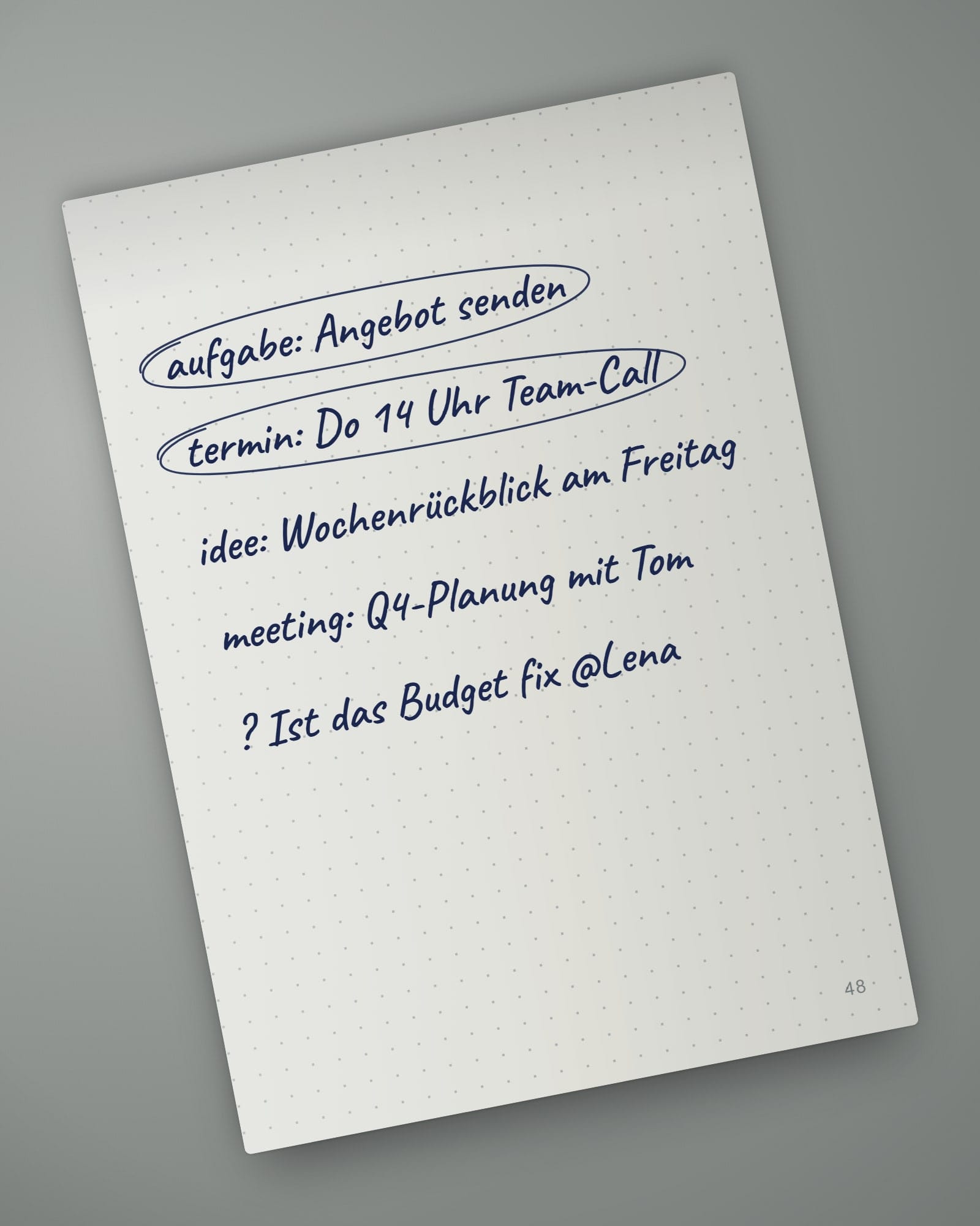 Aufgeschlagene Notizbuchseite 48 mit fünf handschriftlichen Zeilen: aufgabe: Angebot senden, termin: Do 14 Uhr Team-Call, idee: Wochenrückblick am Freitag, meeting: Q4-Planung mit Tom, ? Ist das Budget fix @Lena
